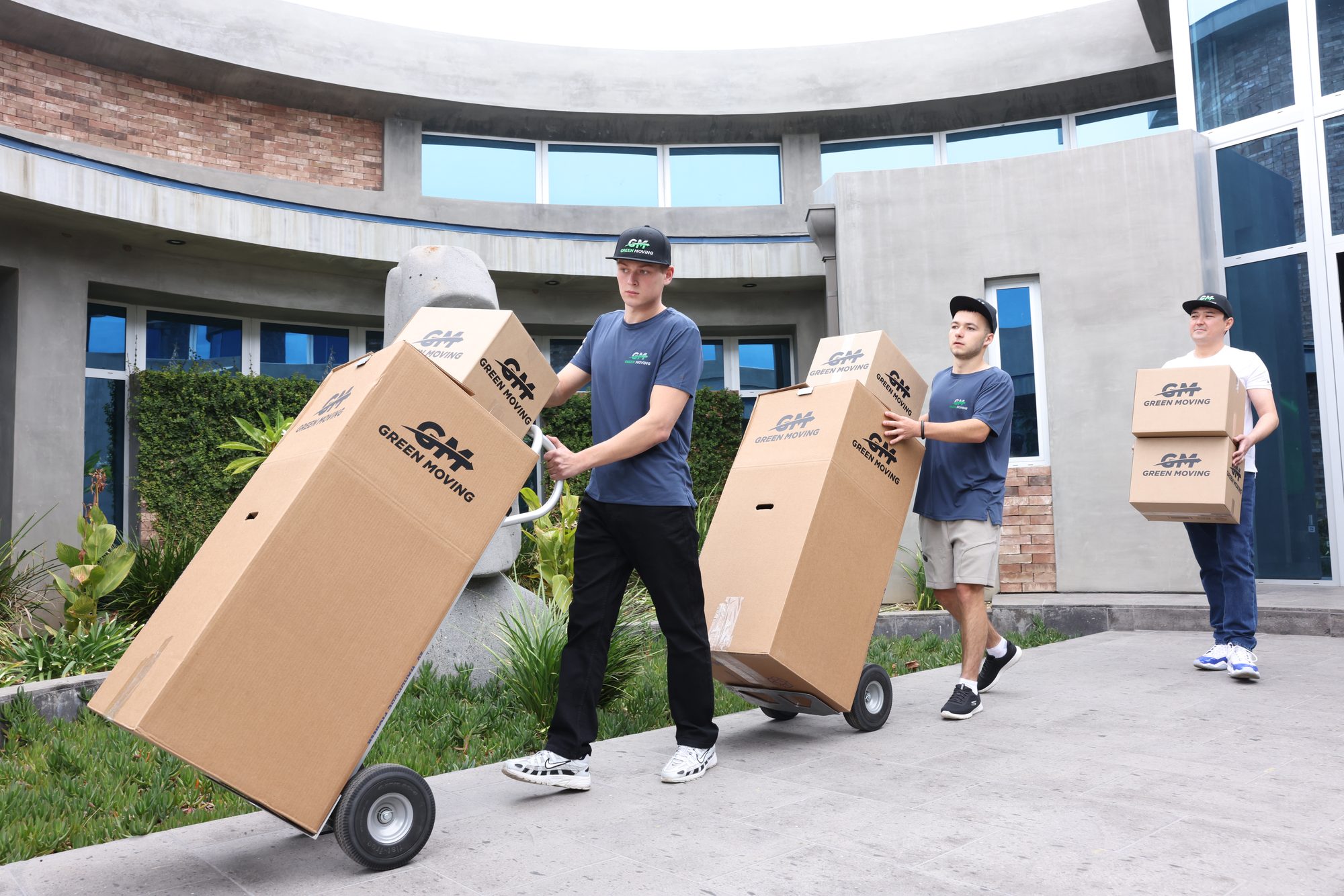 A GreenMoving crew carrying packed boxes out of a home in Los Angeles