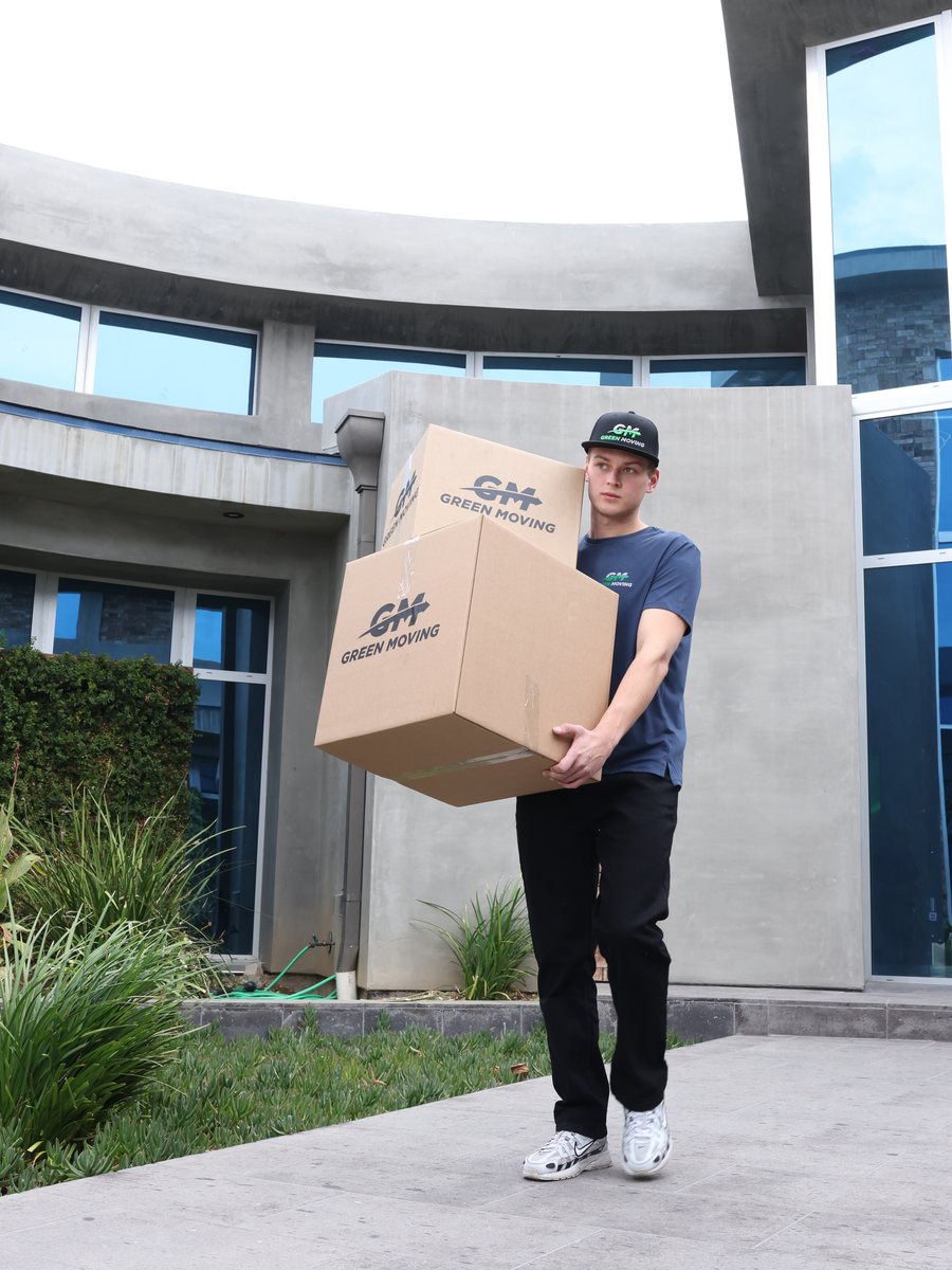 A GreenMoving mover carrying a box out